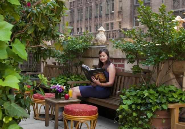 Woman reading on Library Hotel Rooftop Terrace