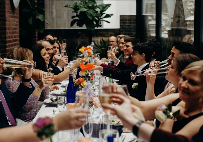 family toasting to bride and groom around the table