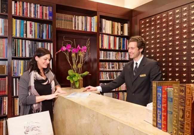 Guest Service Agent assisting a guest at the front desk.